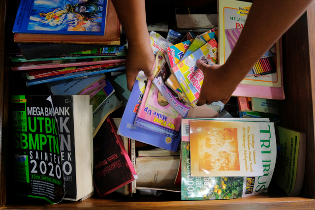Petugas mengumpulkan buku sumbangan dari masyarakat sebelum ditata pada rak lemari perpustakaan desa. Foto: Nyoman Hendra Wibowo/ANTARA FOTO