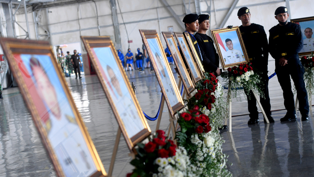 Sejumlah prajurit Kapal Selam TNI AL berpose di samping deretan foto prajurit KRI Nanggala-402 yang gugur. Foto: Zabur Karuru/ANTARA FOTO