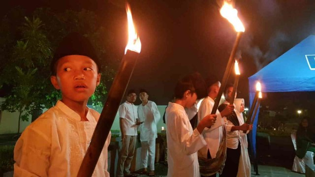 Anak-anak terlihat membawa obor dalam Festival Ela-ela 2019 di Kota Ternate, Maluku Utara. Foto: Faris Bobero/cermat