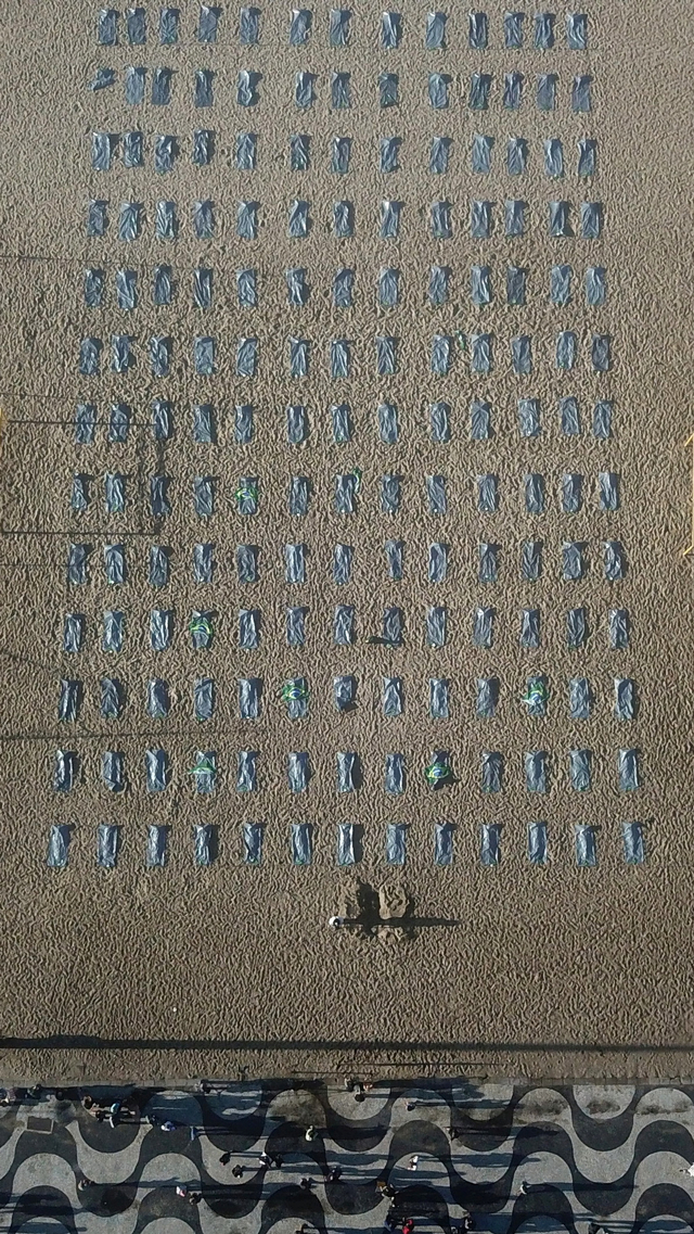 Ratusan kantong mayat kosong dipajang oleh LSM Rio de Paz, di pantai Copacabana, di Rio de Janeiro, Brasil, Jumat (30/1). Foto: Pilar Olivares/REUTERS