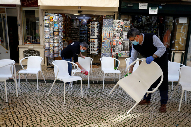Pekerja mempersiapkan toko jelang pelonggaran lockdown di Portugal. Foto: Pedro Nunes/REUTERS