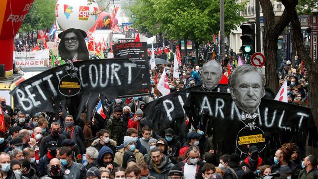 Demonstran membawa spanduk selama pawai serikat pekerja May Day tradisional, di Paris, Prancis, Sabtu (1/5). Foto: Gonzalo Fuentes/REUTERS