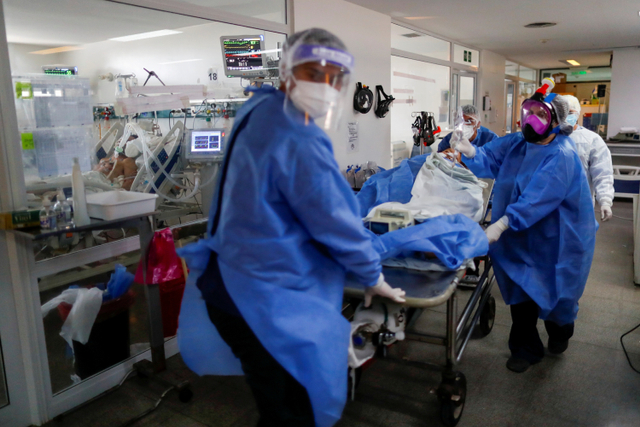 Petugas kesehatan membawa pasien terinfeksi virus corona di unit perawatan intensif Rumah Sakit di Buenos Aires, Argentina. Foto: Agustin Marcarian/REUTERS