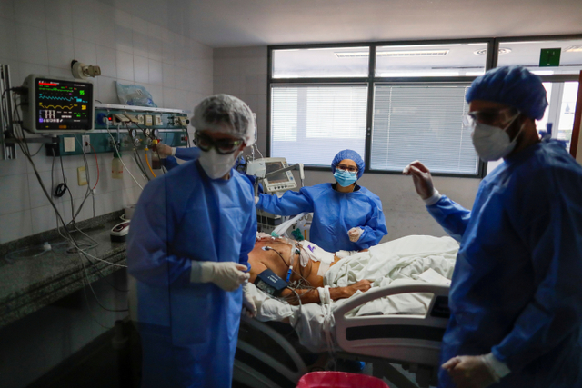 Petugas kesehatan memeriksa pasien terinfeksi virus corona di unit perawatan intensif Rumah Sakit di Buenos Aires, Argentina. Foto: Agustin Marcarian/REUTERS