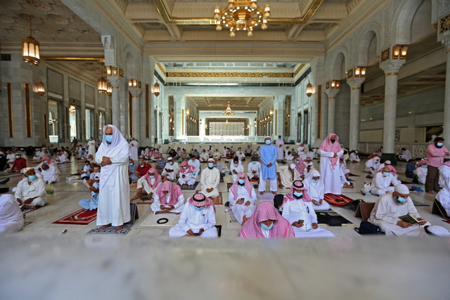 Jemaah memakai masker saat salat Jumat di sekitar Ka'bah, kompleks Masjidil Haram, Mekkah, Arab Saudi.  Foto: AFP