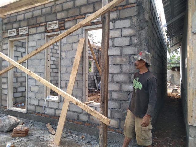 Iswahyudi saat ikut membantu pembangunan rumahnya. foto: Rizal Adhi