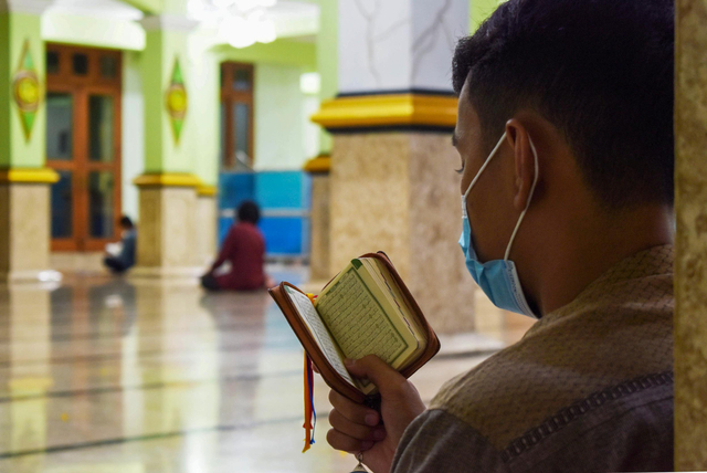 Umat muslim membaca Al Quran saat beriktikaf di Masjid Agung Baitul Hakim Kota Madiun, Jawa Timur, Minggu (2/5/2021) malam. Foto: Siswowidodo/ANTARA FOTO