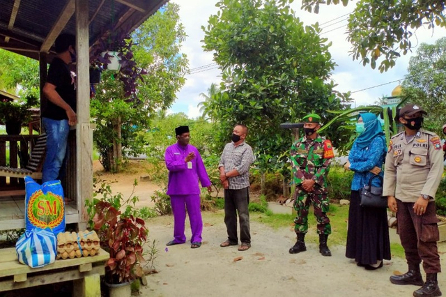 Camat Singkep Barat, Febrizal Taufik (Baju ungu) bersama rombongan menyerahkan sembako untuk keluarga terkonfirmasi positif Corona (Foto:ist)