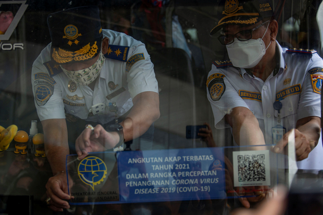 Direktur Angkutan BPTJ Aca Mulyana (kiri) dan Kepala Terminal Bus Terpadu Pulogebang Bernard Pasaribu (kanan) memasang stiker khusus pada armada bus. Foto: Aditya Pradana Putra/Antara Foto