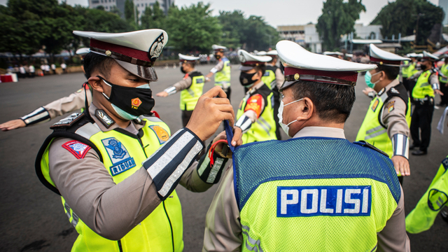 Polisi Lalu Lintas memasangkan pita tanda operasi Ketupat Jaya 2021 kepada rekannya saat mengikuti apel Gelar Pasukan Operasi Ketupat Jaya 2021 di Polda Metro Jaya, Jakarta, Rabu (5/5/2021). Foto: Aprillio Akbar/ANTARA FOTO