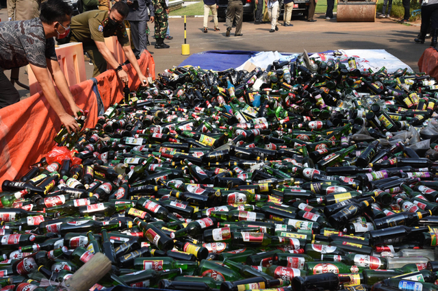 Personel Satpol PP menumpuk ribuan botol minuman keras (miras) ilegal untuk dimusnahkan di halaman Kantor Pemkot Cilegon, Banten, Selasa (27/4).  Foto: Asep Fathulrahman/ANTARA FOTO