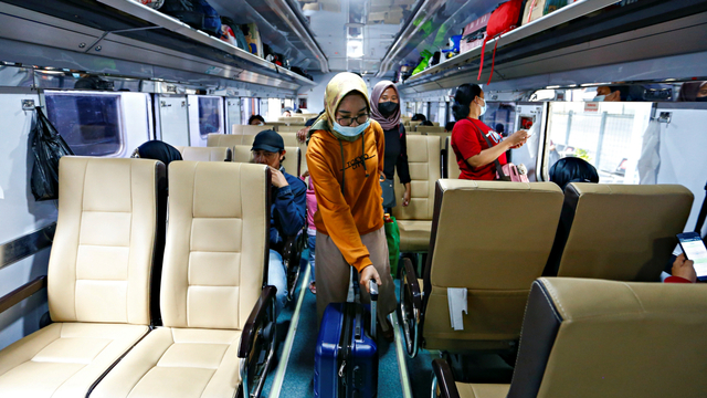 Penumpang membawa kopernya saat berjalan di dalam gerbong kereta, di Jakarta, Rabu (5/5). Foto: Ajeng Dinar Ulfiana/REUTERS