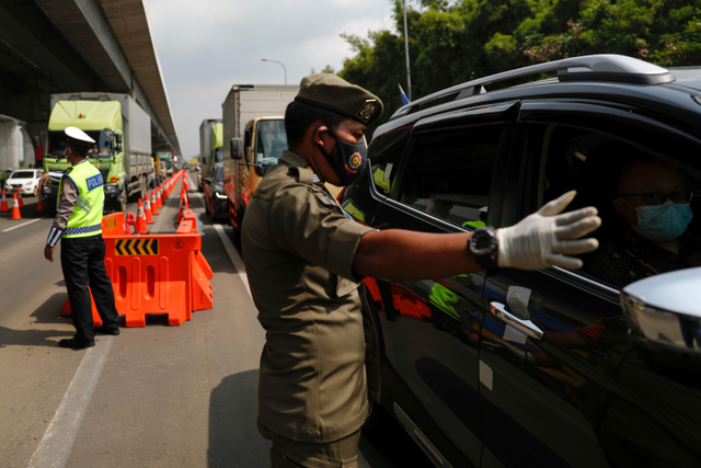 Polisi mengatur lalu lintas kendaraan saat penyekatan di jalan Tol Jakarta-Cikampek, Karawang, Jawa Barat, Kamis (6/5).  Foto: Willy Kurniawan/REUTERS