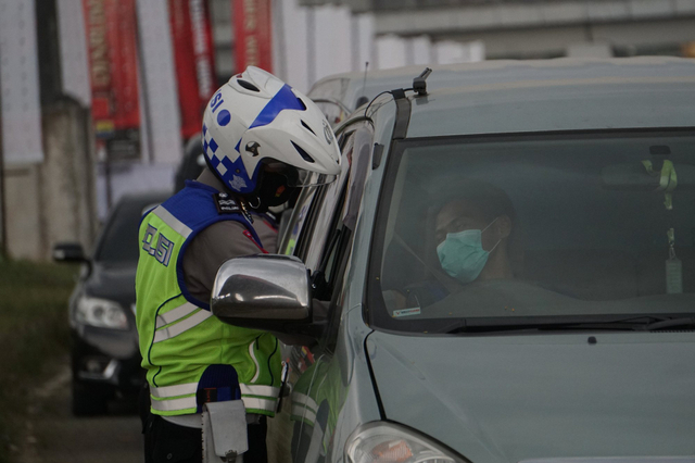 Polisi melakukan pemeriksaan kelengkapan pengendara saat penyekatan di setelah pintu tol Cileunyi, Kab. Bandung, Jawa Barat (6/5/2021). Foto: Jamal Ramadhan/kumparan