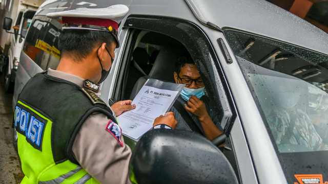 Petugas Kepolisian memeriksa dokumen pengendara yang melintas di check point penyekatan arus mudik Gerbang Tol Cikupa, Tanggerang, Kamis (6/5/2021). Foto: Galih Pradipta/ANTARA FOTO