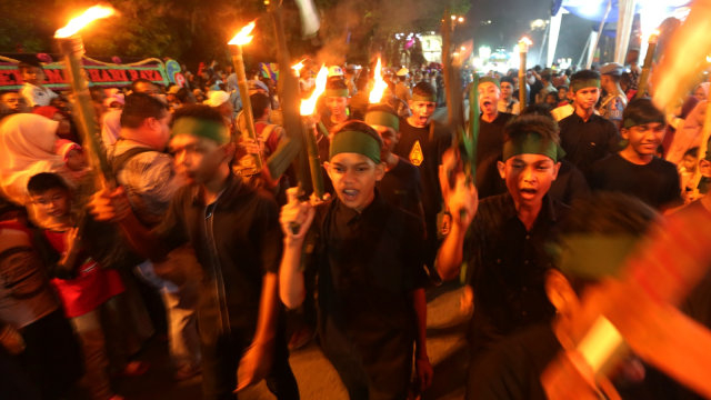 Peserta membawa obor dan bendera palestina saat mengikuti pawai takbiran Idul Fitri 1440 Hijriah di Banda Aceh, Aceh, Selasa (4/6). Foto: ANTARA FOTO/Irwansyah Putra