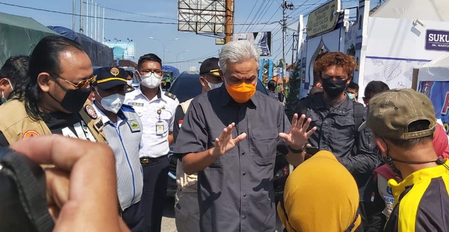 Gubernur Ganjar Pranowo mengimbau warga saat mengecek posko penyekatan di depan pintu masuk Terminal Bus Kota Tegal, Minggu (9/5/2021). (setyadi/panturapost.com)