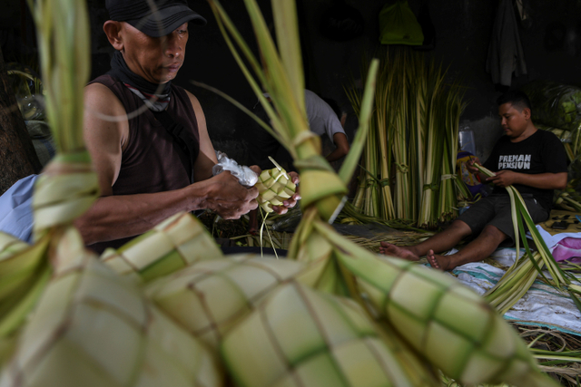 Pedagang kulit ketupat musiman menyelesaikan pembuatan kulit ketupat yang dijual di kawasan Palmerah, Jakarta, Minggu (9/5). Foto: M Risyal Hidayat/ANTARA FOTO