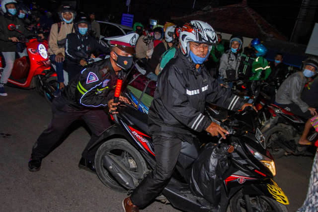 Petugas kepolisian menertibkan pemudik motor yang berhenti di pinggir ruas jalan setelah diputar balik di jalur pantura Karawang, Jawa Barat, Senin (10/5).  Foto: M Ibnu Chazar/ANTARA FOTO