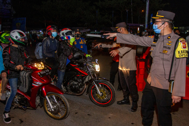 Polisi menghalau pemudik motor yang melintas di jalur pantura Karawang, Jawa Barat, Senin (10/5).  Foto: M Ibnu Chazar/ANTARA FOTO
