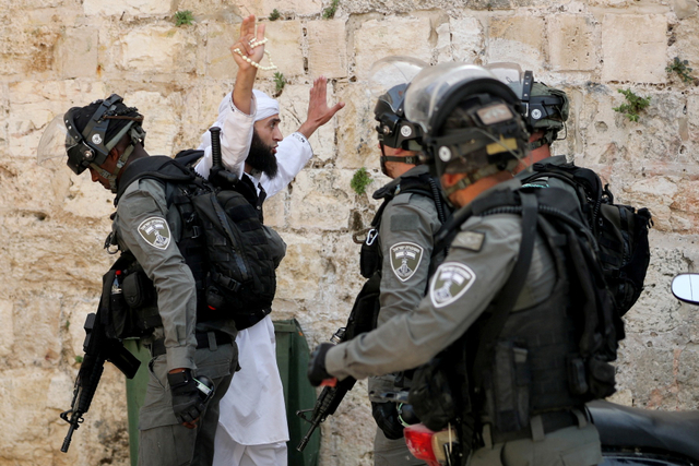 Seorang warga Palestina mengangkat tangan selama bentrokan di kompleks Masjid Al-Aqsa di Yerusalem.  Foto: Ammar Awad/REUTERS