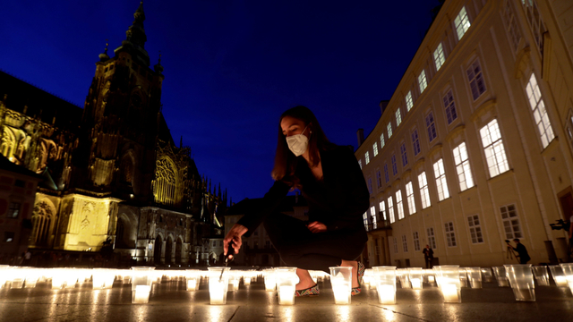 Sejumlah orang menyalakan lilin di alun-alun untuk menghormati korban yang gugur akibat pandemi COVID-19. Foto: REUTERS/David W Cerny