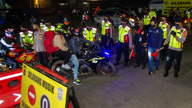 Petugas gabungan mengarahkan pemudik untuk memutar balik saat melintasi posko penyekatan mudik di jalur Pantura Patokbeusi, Subang, Jawa Barat, Selasa (11/5/2021) dini hari. Foto: M Ibnu Chazar/ANTARA FOTO