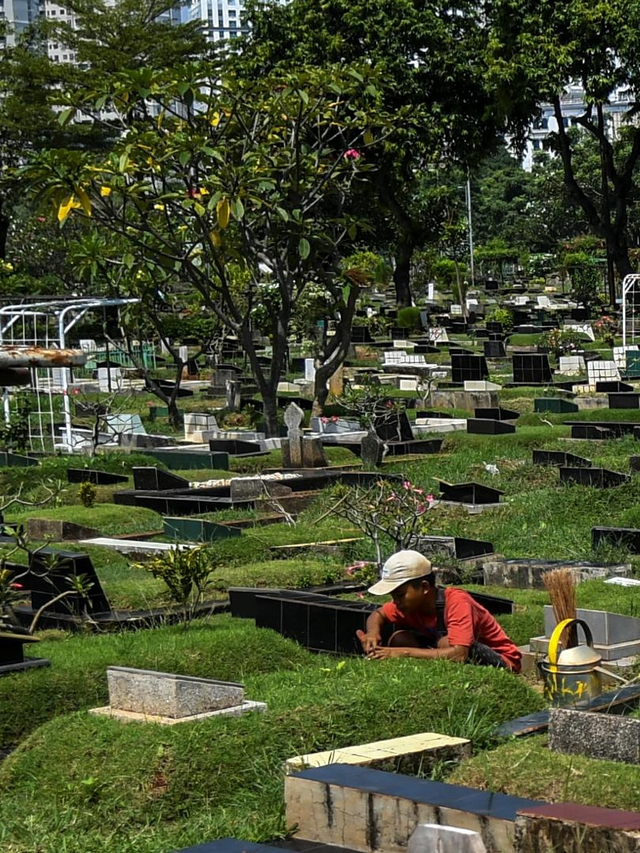 Petugas membersihkan makam di Tempat Pemakaman Umum (TPU) Karet Bivak, Jakarta, Selasa (11/5). Foto: Galih Pradipta/Antara Foto