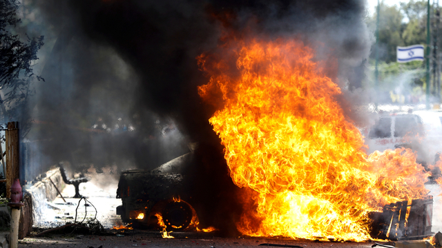 Mobil yang terbakar setelah roket di Israel selatan, Selasa (11/5). Foto: Nir Elias/REUTERS