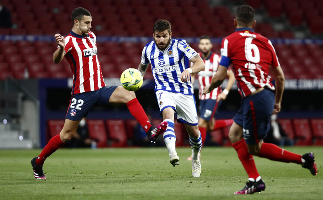 Pemain Real Sociedad, Portu berusaha merebut bola dari hadangan pemain Atletico Madrid Mario Hermoso. Foto: REUTERS / Sergio Perez