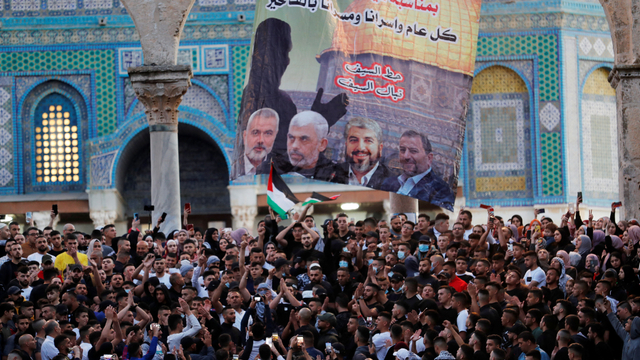 Sebuah spanduk dengan gambar empat pemimpin Hamas tergantung di luar masjid Kubah Batu, di kompleks masjid Al-Aqsa di Yerusalem, Kamis (13/5). Foto: AHMAD GHARABLI/AFP