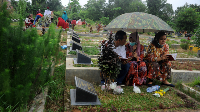 Sejumlah peziarah berdoa di makam sanak keluarga di TPU Kebun Bungan Palembang, Sumsel, Kamis (13/5/2020). Foto: Feny Selly/ANTARA FOTO