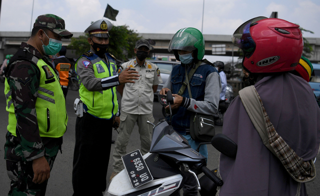 Petugas gabungan memberhentikan pengendara motor di pos penyekatan mudik Sumber Artha, Bekasi, Jawa Barat, Jumat (14/5). Foto: Sigid Kurniawan/ANTARA FOTO