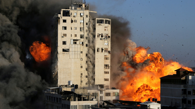 Asap dan api membumbung dari gedung menara saat dihancurkan oleh serangan udara Israel di tengah maraknya kekerasan Israel-Palestina, di Kota Gaza, Rabu (13/5). Foto: Ibraheem Abu Mustafa/REUTERS