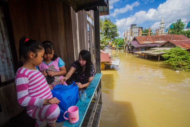 Warga bertahan di rumahnya saat banjir merendam permukiman di Jalan Biduri, Kecamatan Satui, Kabupaten Tanah Bumbu, Kalimantan Selatan, Sabtu (15/5/2021). Foto: BAYU PRATAMA S/ANTARA FOTO