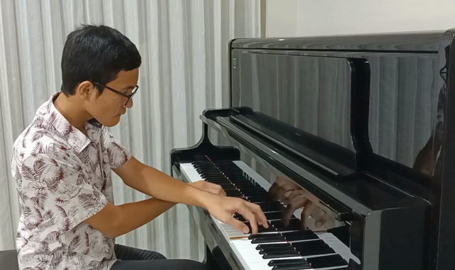 Yosua Panggabean saat mengaransemen lagu daerah dari Batak sebagai persiapan tampil di konser virtual 'Festival Indonesiana 2021'. Foto: Istimewa