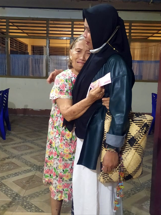Oma Since Pangkey saat memeluk Linda Raihana Ibrahim, perempuan berhijab asal Kota Manado yang membelikannya Alkitab, untuk mengganti alkitab miliknya yang rusak karena terkena tumpahan air