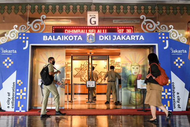 Sejumlah PNS lingkup Pemprov DKI Jakarta berjalan memasuki ruang dinasnya saat hari pertama masuk kerja usai libur lebaran di Balai Kota, Jakarta, Senin (17/5/2021). Foto: M Risyal Hidayat/Antara Foto