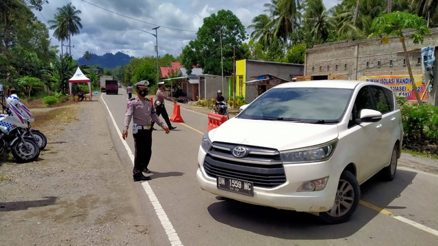 Polisi memutar balik kendaraan yang hendak melintas di perbatasan Sulbar-Sulteng di Dusun Rojo, Desa Sarude, Kecamatan Sarjo, Pasangkayu. Foto: Dok. Polres Pasangkayu