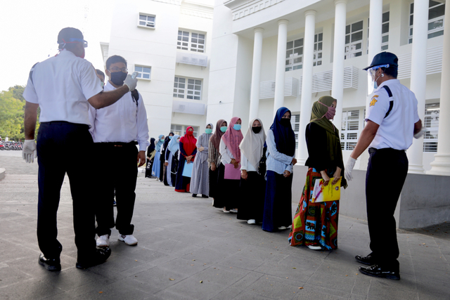 Peserta UTBK SBMPTN di Universitas Syiah Kuala (USK), Aceh, diperiksa suhu tubuh sebelum memasuki ruangan, Minggu (5/7/2020). Foto: Suparta/acehkini