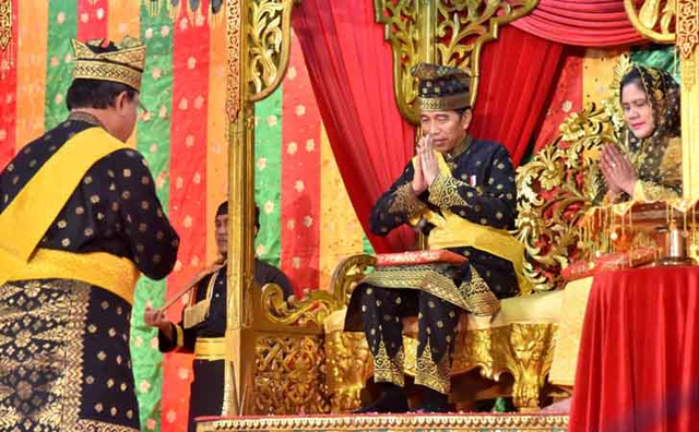 PRESIDEN Joko Widodo dan istri saat menerima gelar adat dari Lembaga Adat Melayu Riau (LAMR), Sabtu (15/12/2018) silam di Gedung LAMR. 