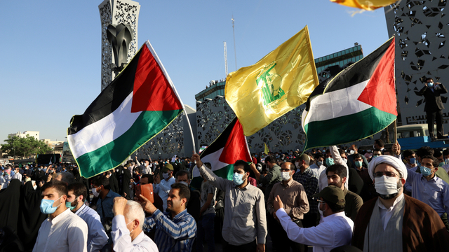 Sejumlah orang mengibarkan bendera pada aksi bela Palestina di Teheran, Iran, Rabu (19/5). Foto: WANA (West Asia News Agency) via REUTERS