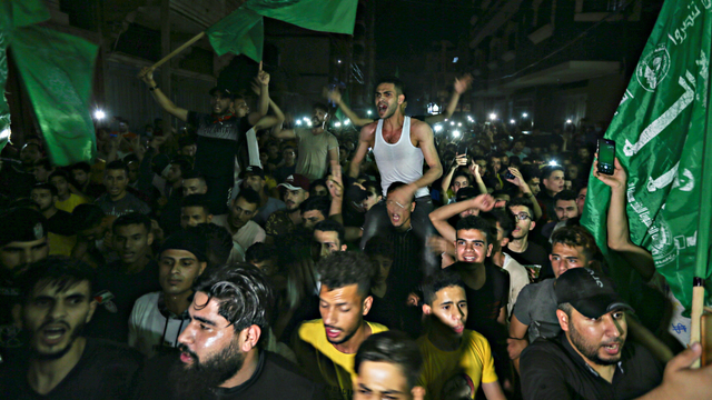 Warga Palestina bersorak untuk merayakan keputusan gencatan senjata, di Jalur Gaza selatan, Jumat (21/5). Foto: Ibraheem Abu Mustafa/REUTERS