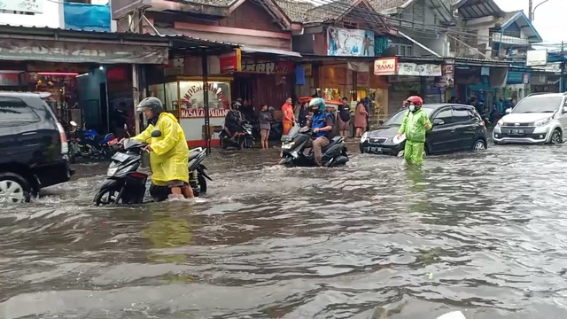 Warga mendorong motor yang terjebak banjir di Pasar Panorama Lembang, Bandung, Jumat (21/5).  Foto: Dok. Istimewa