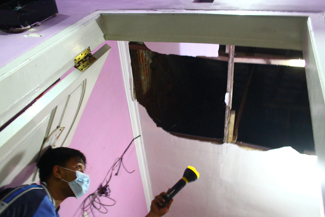 Seorang warga melihat kerusakan atap sebuah rumah yang ambrol akibat gempa di perumahan Griya Tirta Aji, Malang, Jawa Timur, Jumat (21/5).  Foto: Ari Bowo Sucipto/ANTARA FOTO