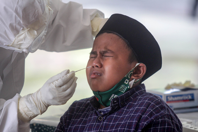 Petugas melakukan tes usap antigen kepada santri pondok pesantren Lirboyo di Puskesmas Pagu, Kediri, Jawa Timur, Sabtu (22/5/2021). Foto: Umarul Faruq/ANTARA FOTO