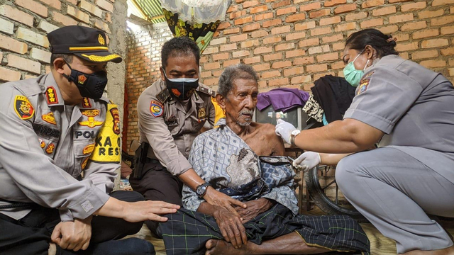 KAPOLRESTA Pekanbaru, Kombes Pol Nandang Mu'min Wijaya, saat mendampingi kakek Kadir (90), yang menerima vaksin COVID-19 dari Polresta Pekanbaru, Senin (24/5/2021). 