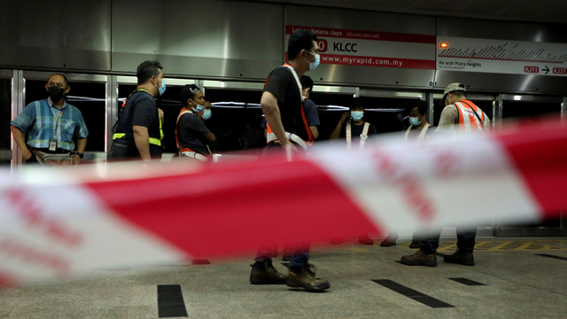 Petugas polisi berjaga di lokasi kecelakaan dua kereta LRT yang bertabrakan di terowonan bawah tanah di Stasiun Kuala Lumpur, Malaysia, Selasa (25/5).  Foto: Lim Huey Teng/REUTERS