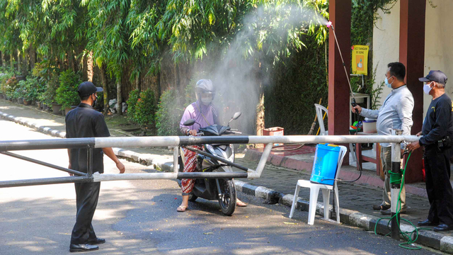Warga disemprot disinfektan saat keluar dari Perumahan Griya Melati, Kelurahan Bubulak, Kota Bogor, Jawa Barat, Rabu (26/5/2021).  Foto: Arif Firmansyah/ANTARA FOTO