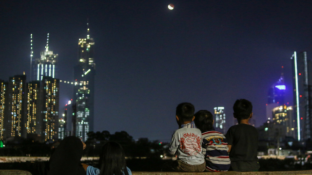 Warga melihat gerhana bulan di wilayah Petamburan, Jakarta, Rabu (26/5/2021). Foto: Rivan Awal Lingga/ANTARA FOTO